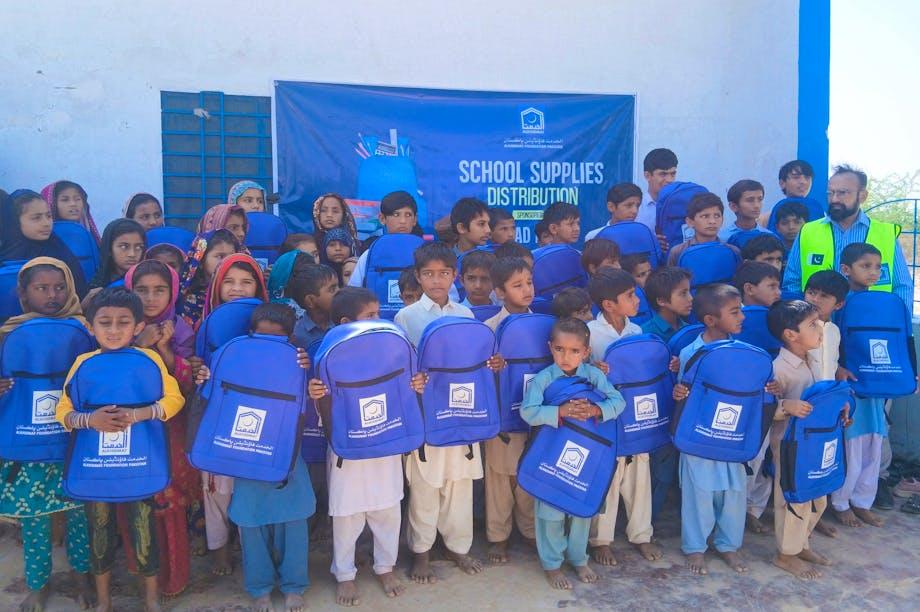 Children receiving school backpacks and supplies